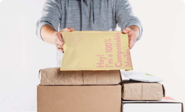 person_packaging_items_into_compostable_mailers 