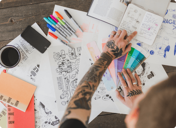 sketching_product_ideas_with_markers_notebooks_and_color_swatches_on_desk